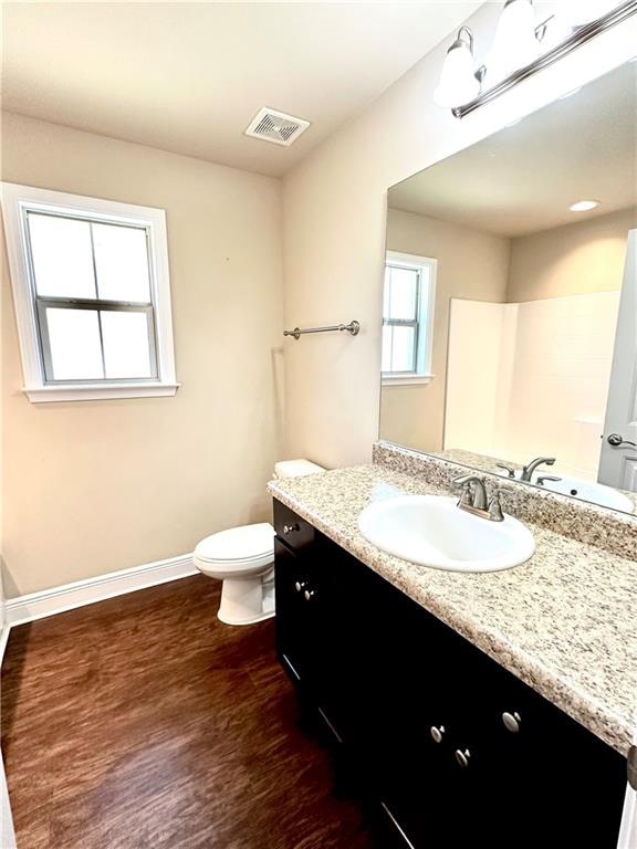 bathroom with hardwood / wood-style flooring, vanity, and toilet