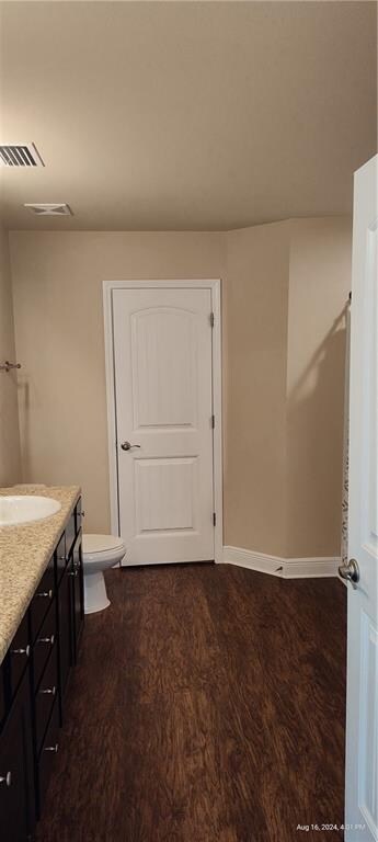 bathroom with toilet, hardwood / wood-style flooring, and vanity