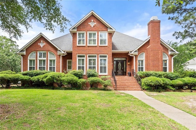 704 Providence Estates Dr E, Mobile, AL 36695 - traditional-style house featuring brick siding, a front yard, and a chimney