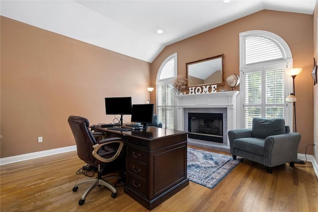 704 Providence Estates Dr E, Mobile, AL 36695 - office with lofted ceiling, light wood-type flooring, a tiled fireplace, and baseboards