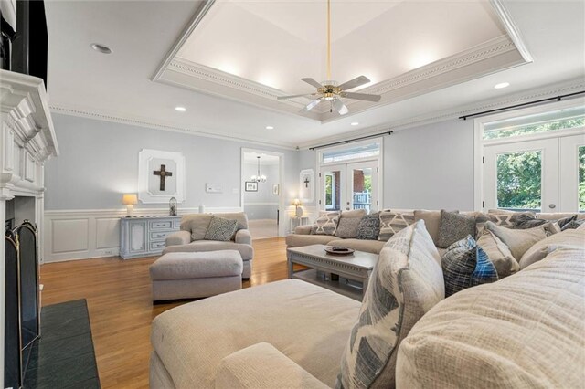 704 Providence Estates Dr E, Mobile, AL 36695 - living room featuring a tray ceiling, french doors, crown molding, a wainscoted wall, and light wood-type flooring