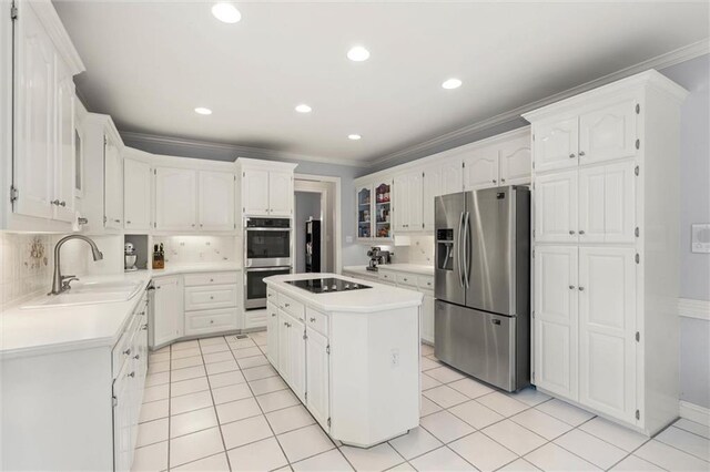 704 Providence Estates Dr E, Mobile, AL 36695 - kitchen featuring appliances with stainless steel finishes, a sink, light countertops, white cabinetry, and ornamental molding