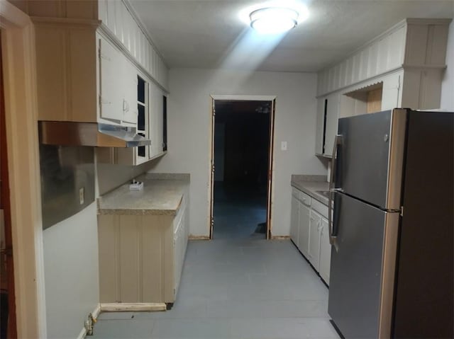 kitchen featuring stainless steel fridge and white cabinets