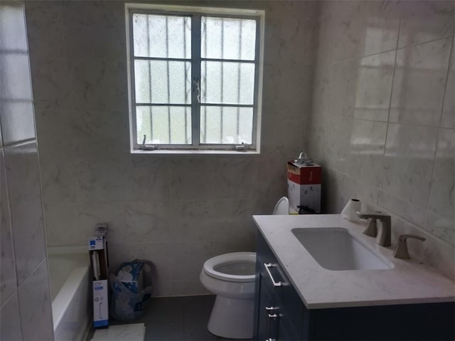 bathroom featuring vanity, toilet, tile walls, and a washtub