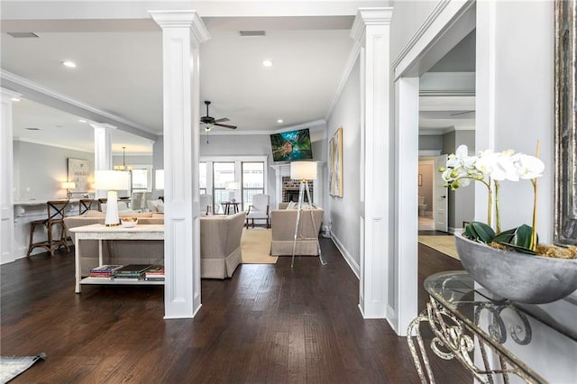 living room featuring ornate columns, ornamental molding, ceiling fan, and dark hardwood / wood-style floors