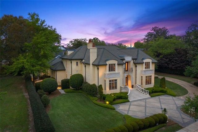 french country style house featuring a lawn