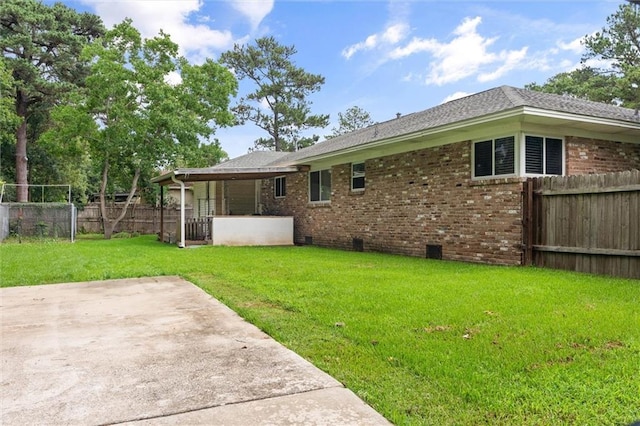 42 Lourando Dr W, Mobile, AL 36606 - rear view of house with a fenced backyard, brick siding, a patio area, crawl space, and roof with shingles