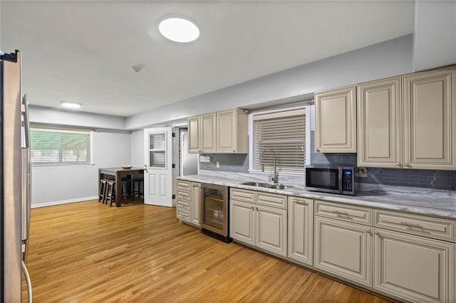 42 Lourando Dr W, Mobile, AL 36606 - kitchen featuring beverage cooler, stainless steel appliances, tasteful backsplash, and light wood-style flooring