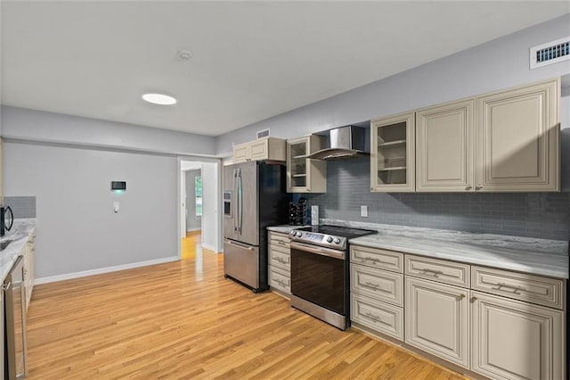 42 Lourando Dr W, Mobile, AL 36606 - kitchen featuring appliances with stainless steel finishes, wall chimney exhaust hood, cream cabinetry, backsplash, and light countertops