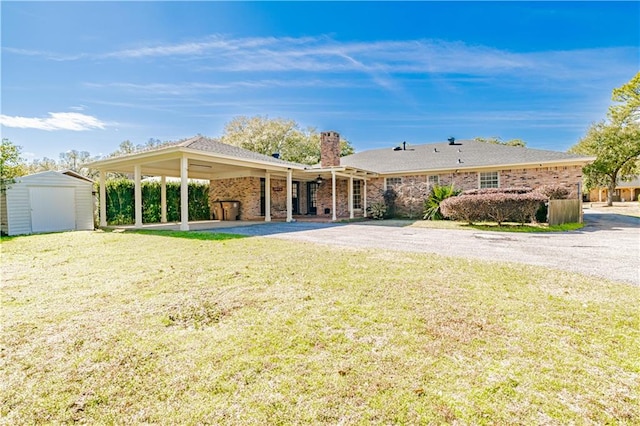 rear view of property featuring a patio, a yard, and a shed