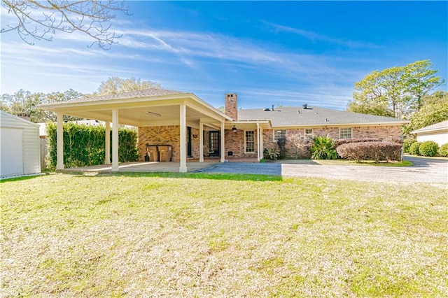 back of house with a patio area and a lawn