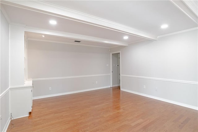 spare room featuring beamed ceiling, ornamental molding, and light hardwood / wood-style flooring