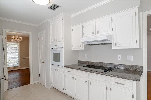 kitchen featuring white oven, white cabinetry, light tile flooring, a notable chandelier, and crown molding