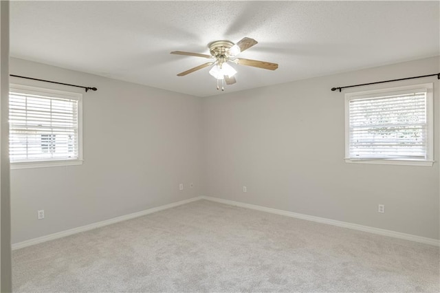 carpeted empty room with plenty of natural light and ceiling fan