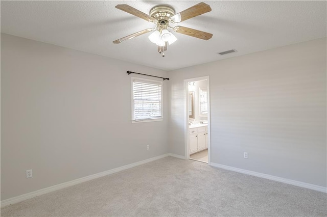 unfurnished bedroom with light carpet, ceiling fan, and ensuite bathroom