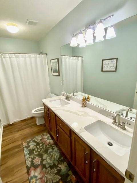 bathroom featuring vanity, toilet, and hardwood / wood-style floors