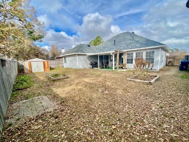 back of house with a storage shed