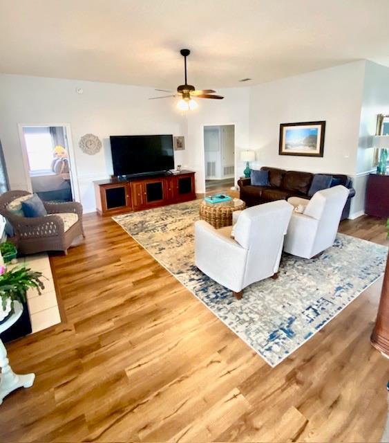 living room featuring hardwood / wood-style floors and ceiling fan