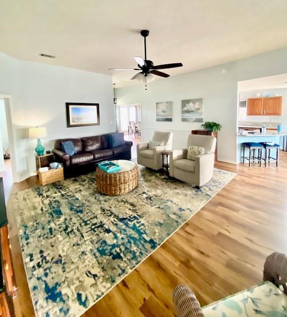 living room featuring ceiling fan and light hardwood / wood-style flooring