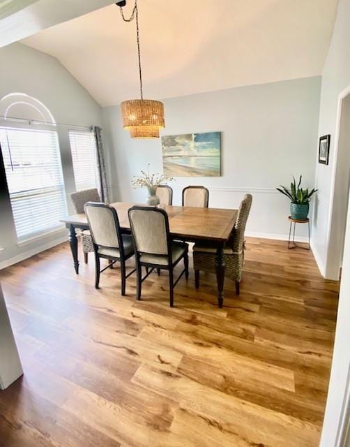 dining area with lofted ceiling and hardwood / wood-style flooring