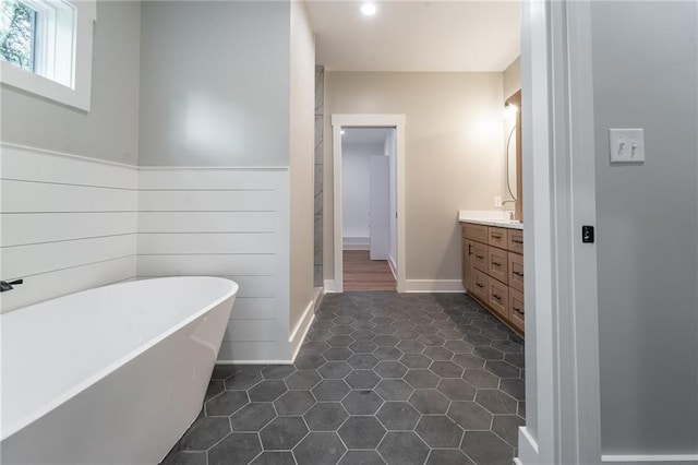 full bathroom with vanity, tile patterned floors, recessed lighting, a freestanding bath, and baseboards