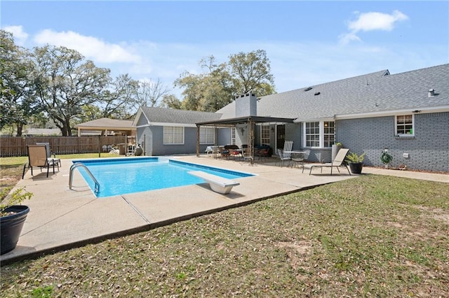 view of swimming pool with a fenced in pool, fence, a diving board, a patio area, and a lawn