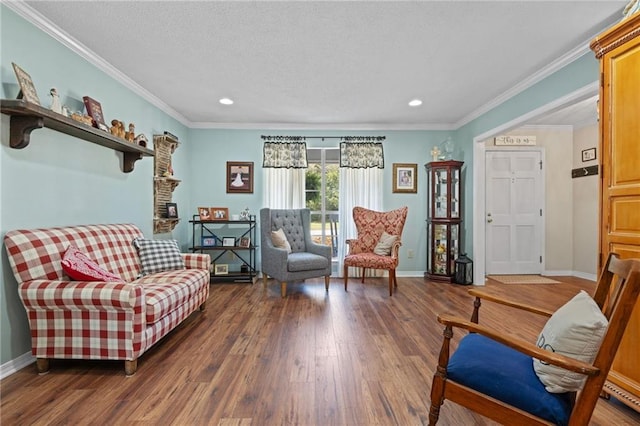 living area featuring crown molding, wood finished floors, baseboards, and a textured ceiling