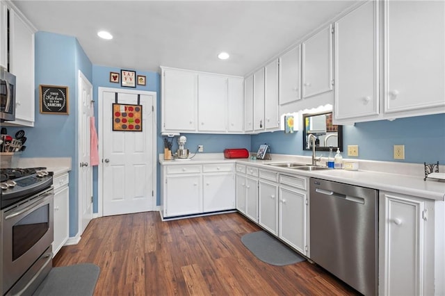 kitchen featuring dark wood finished floors, light countertops, stainless steel appliances, white cabinetry, and a sink