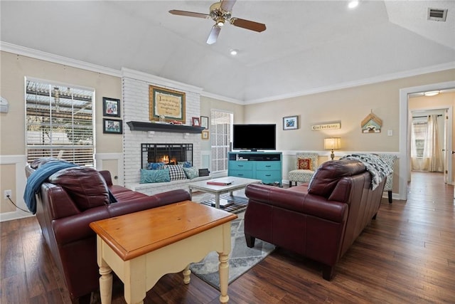 living area with visible vents, ornamental molding, a fireplace, lofted ceiling, and dark wood-style flooring