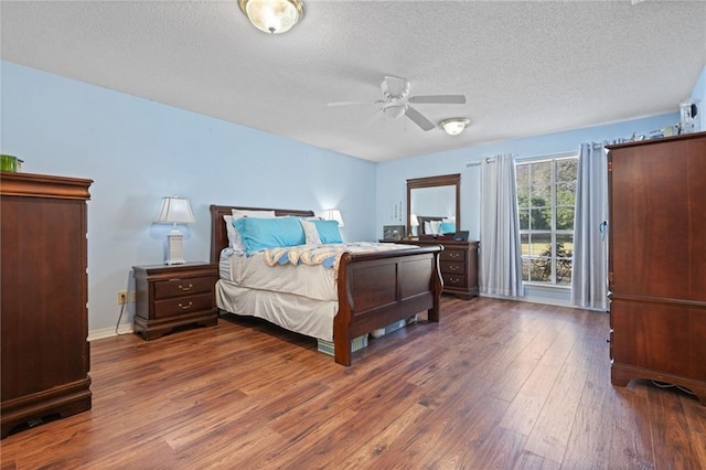 bedroom with ceiling fan, baseboards, a textured ceiling, and hardwood / wood-style floors