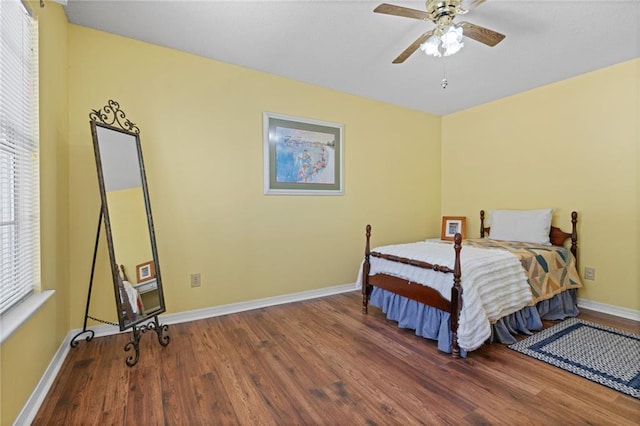 bedroom with ceiling fan, baseboards, and wood finished floors