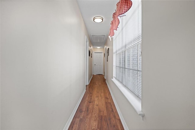 hall with baseboards and wood finished floors