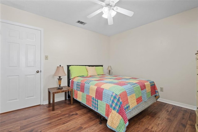 bedroom featuring a ceiling fan, wood finished floors, visible vents, and baseboards