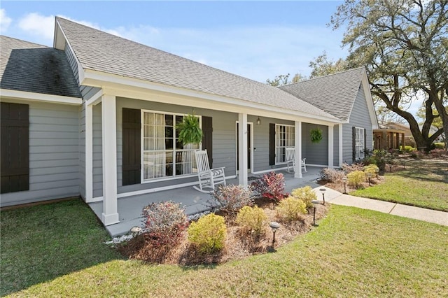 view of front of home featuring a porch, a front yard, and roof with shingles