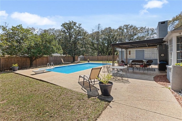 view of swimming pool featuring a patio, a fenced in pool, a yard, a fenced backyard, and a diving board