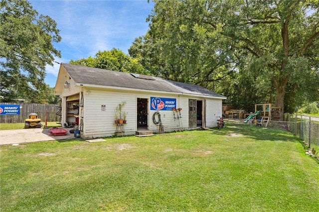 view of outbuilding featuring a playground and a lawn