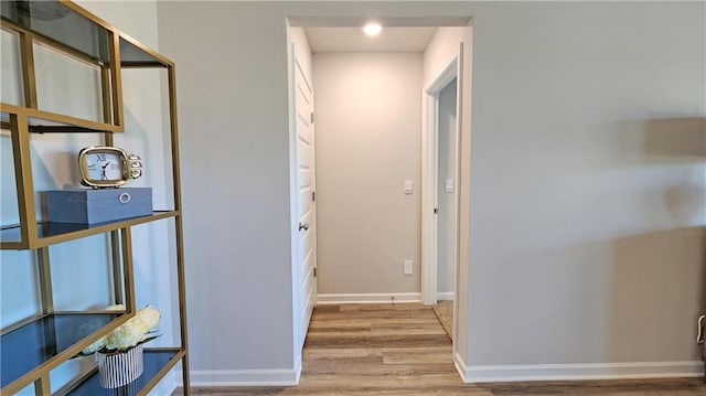 corridor featuring wood finished floors and baseboards
