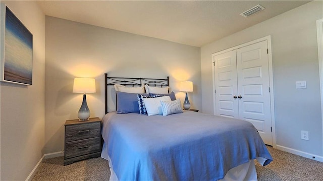carpeted bedroom featuring a closet, visible vents, and baseboards