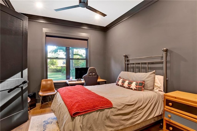 bedroom with ceiling fan, light wood-type flooring, and crown molding