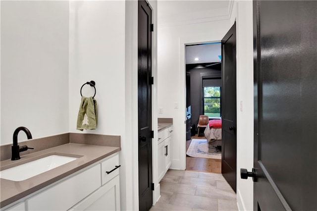 bathroom with hardwood / wood-style floors, vanity, and crown molding