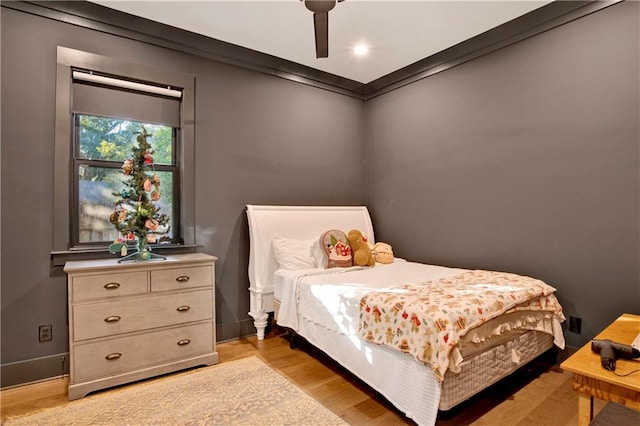 bedroom with ceiling fan, ornamental molding, and light wood-type flooring