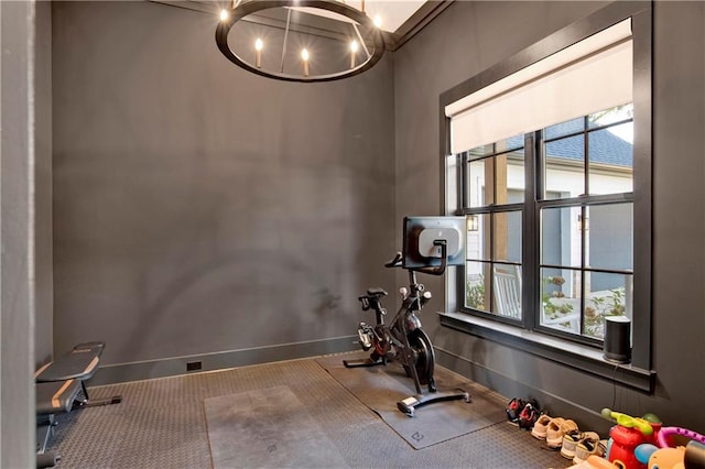 workout area with carpet flooring, plenty of natural light, and an inviting chandelier