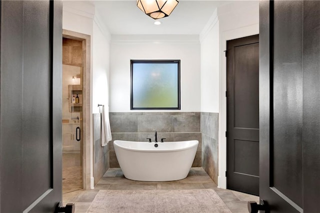 bathroom featuring tile patterned flooring, shower with separate bathtub, ornamental molding, and tile walls