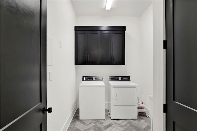 laundry room with light parquet flooring, cabinets, and independent washer and dryer