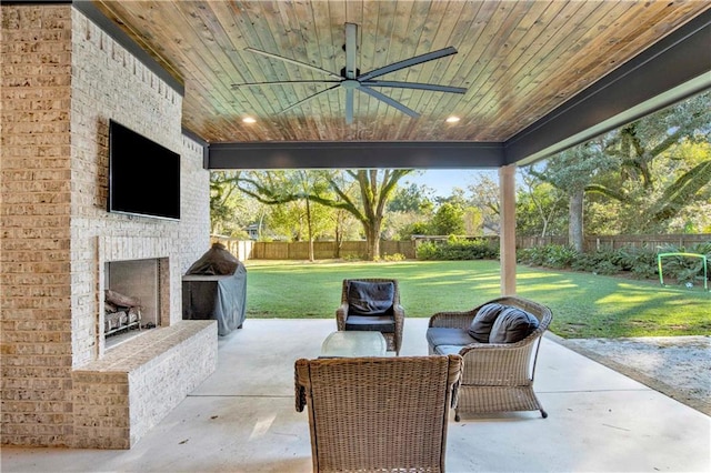 view of patio with an outdoor stone fireplace and ceiling fan