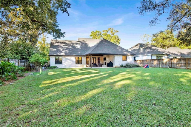 rear view of house featuring a lawn