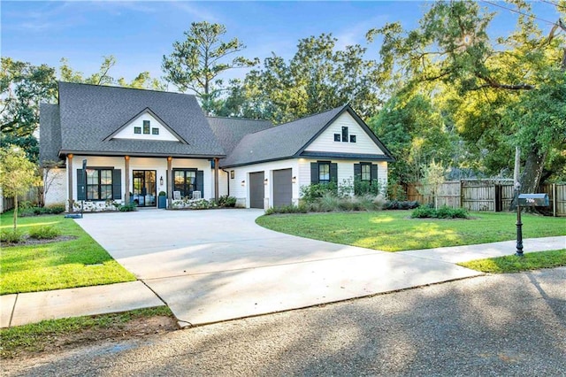 view of front of house featuring covered porch, a garage, and a front lawn