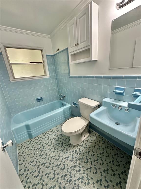 full bathroom with tile walls, backsplash, toilet, tub / shower combination, and tile flooring