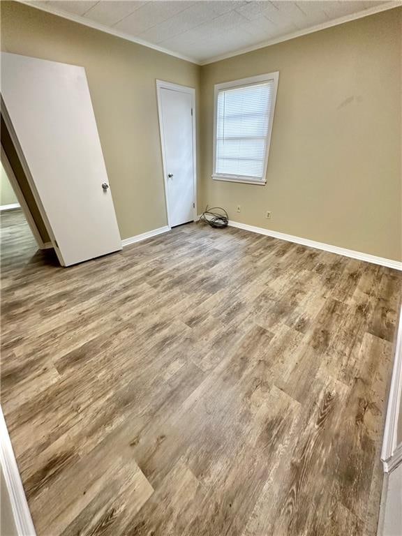 empty room featuring ornamental molding and hardwood / wood-style flooring