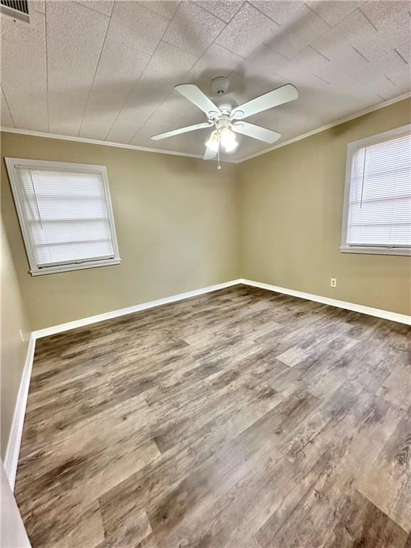 empty room with hardwood / wood-style floors, ceiling fan, and crown molding